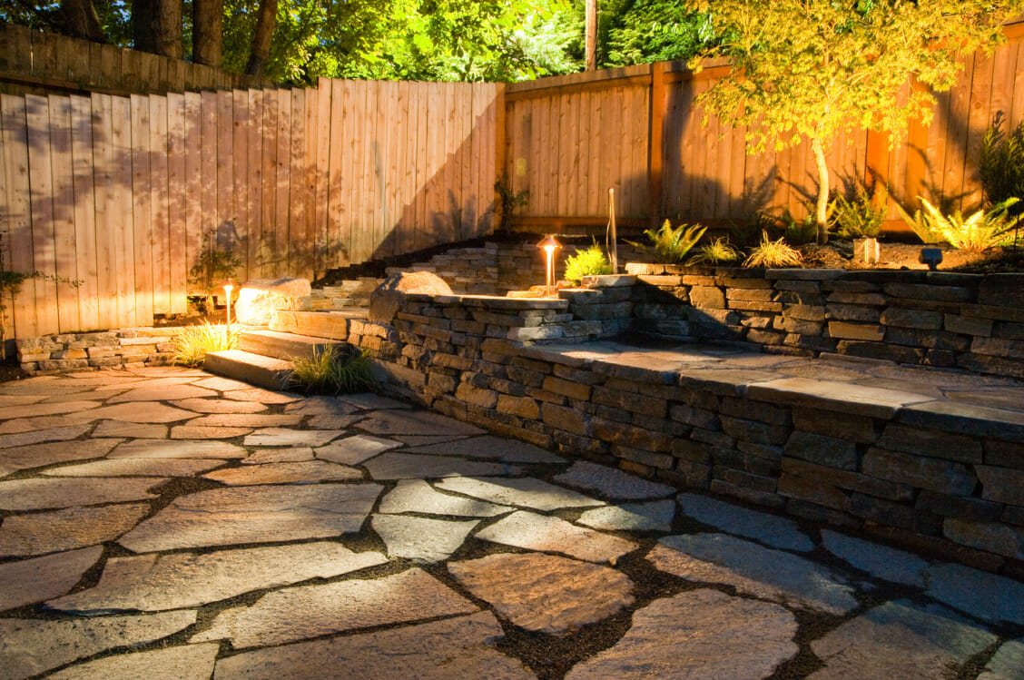 Stone-paved backyard lit up with solar lights